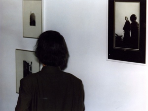 1990-Takemitsu next to a picture of himself in traditional Japanese dress taken in1969.
